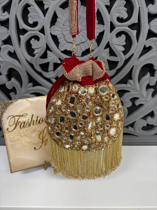 Decorative gold and red bag with intricate patterns on a white surface.