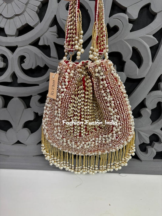 Decorative handbag with beads and pearls against a decorative wall.