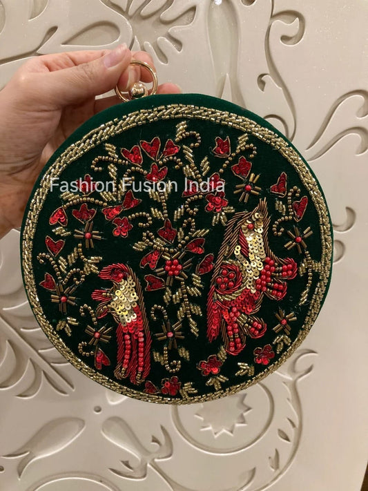 Round embroidered clutch with parrot design held by a hand against a decorative white background.