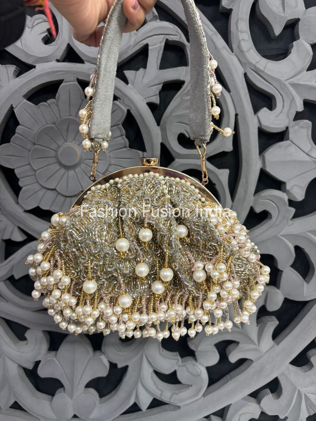 Decorative handbag with pearls against a decorative wall