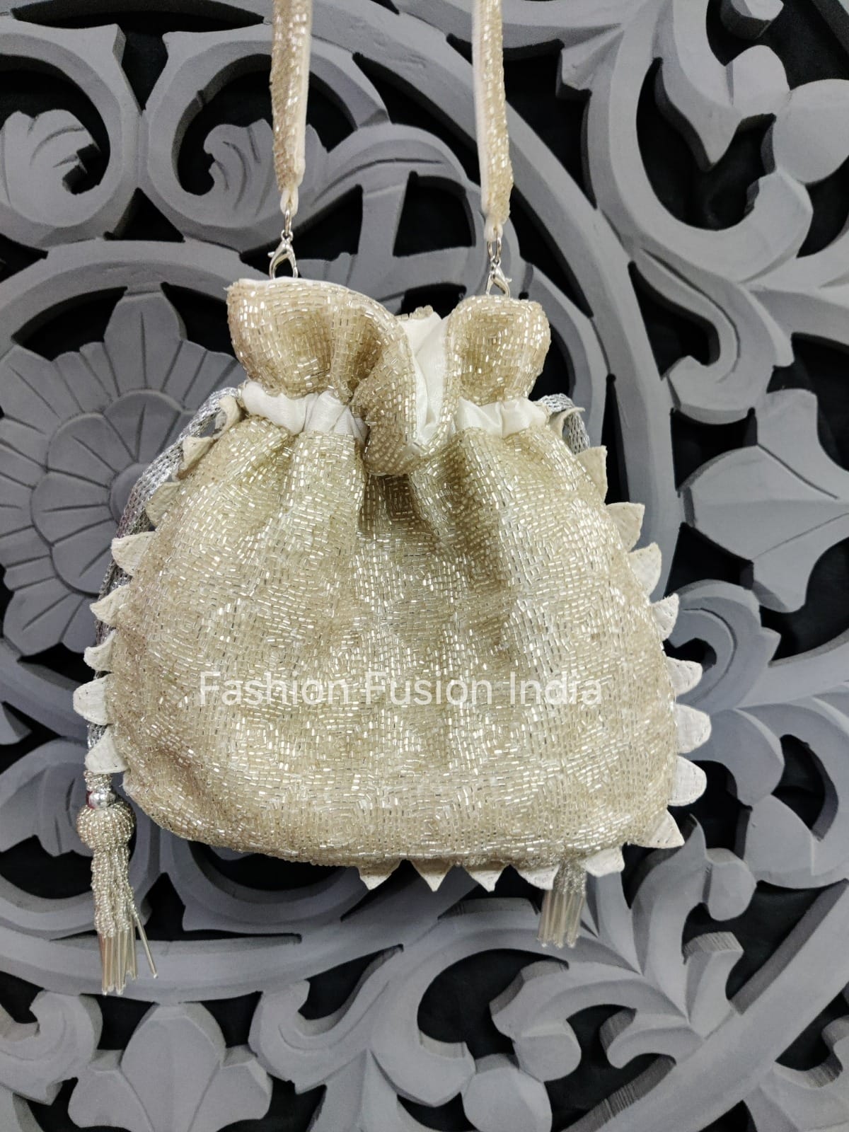 Decorative bag with tassels on a decorative background, featuring 'Fashion Fusion India' branding.