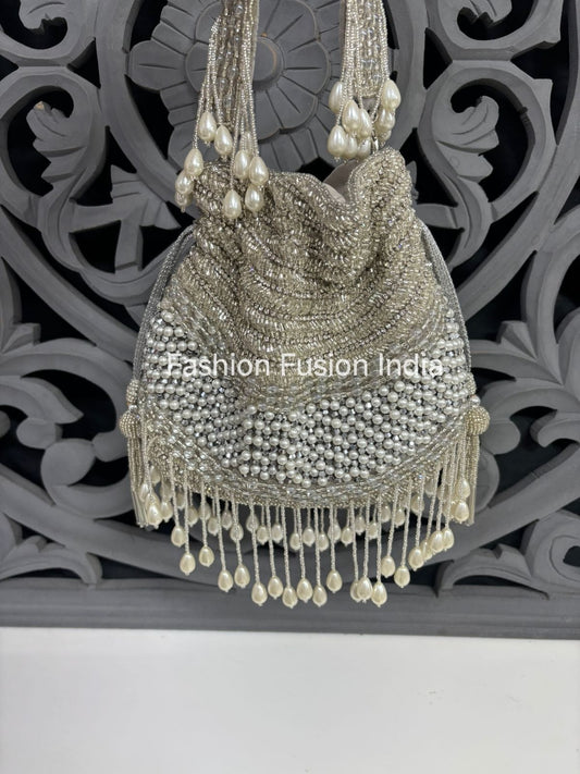 Silver beaded handbag with tassels on a decorative background