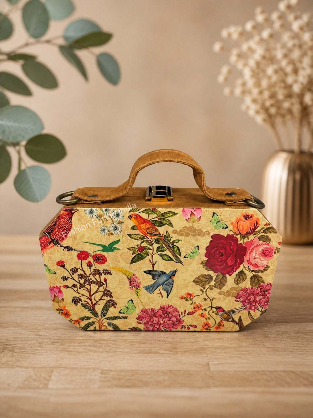 Floral and bird patterned handbag on a wooden surface with a neutral background