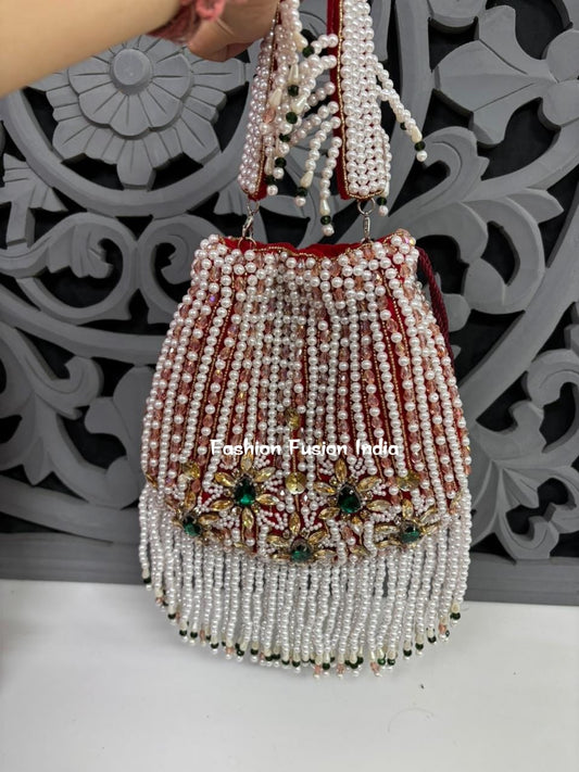 Beaded handbag with decorative elements on a white surface with a decorative wall background.