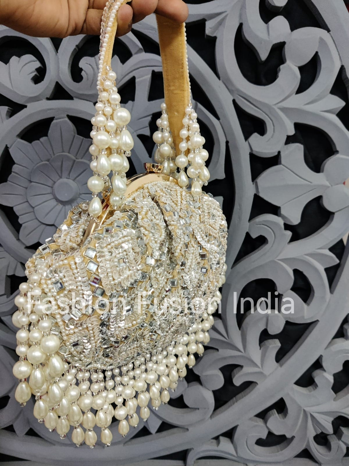 Decorative handbag with pearls and crystals against a decorative background