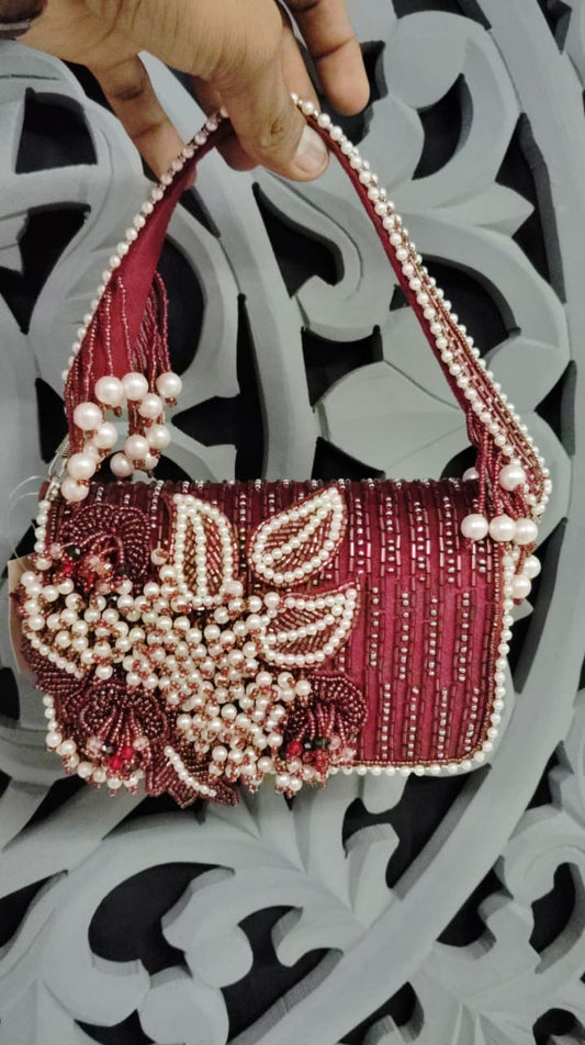 Decorative handbag with intricate beadwork held against a decorative background