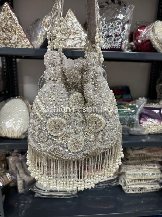 Decorative handbag with pearls and beads on a shelf with other decorative items.