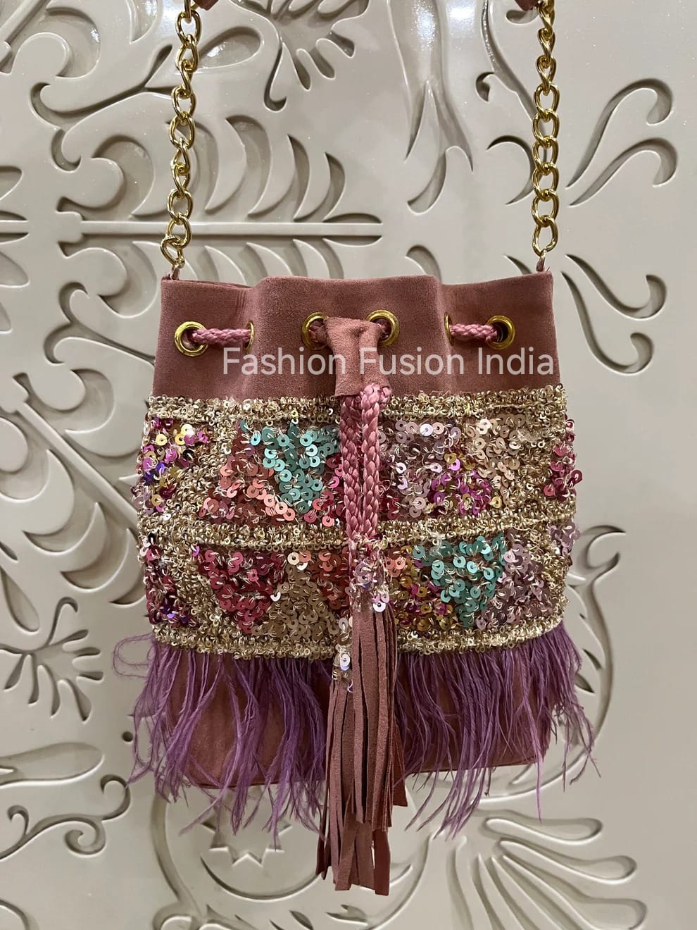 Decorative handbag with sequins and feathers on a white background