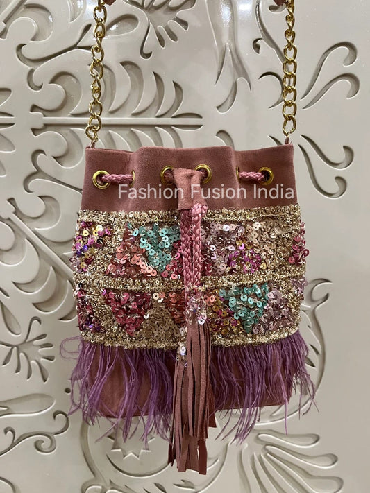 Decorative handbag with sequins and feathers on a white background