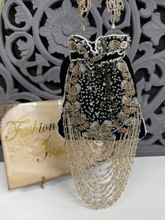Elegant beaded dress with gold and black details on a mannequin against a decorative wall.