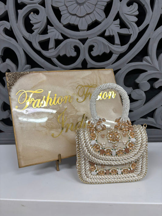 Decorative handbag with floral patterns on a stand with 'Fashion Fusion India' sign in the background.