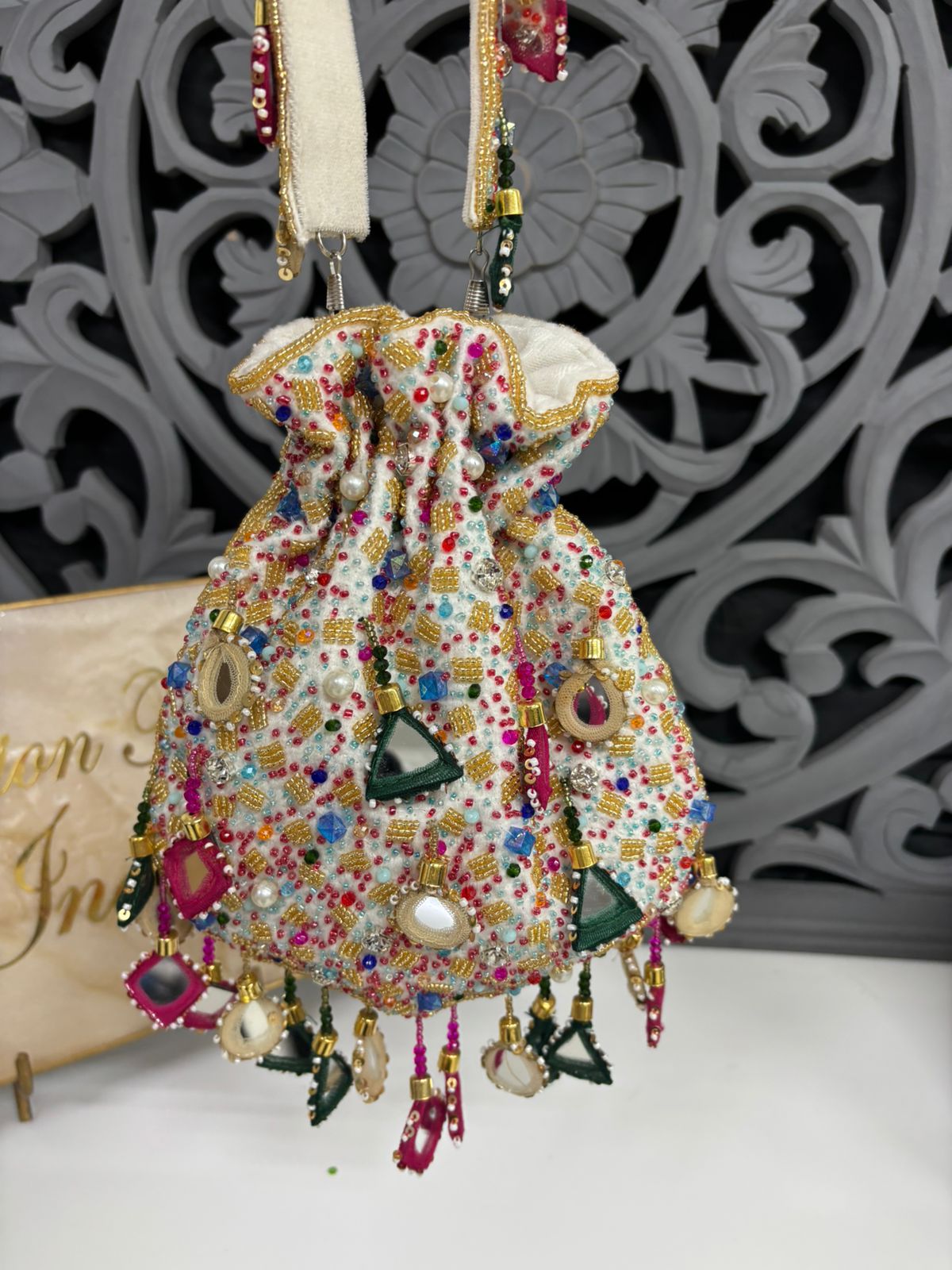 Decorative handbag with colorful beads and pearls against a decorative background