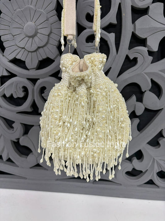 Beaded handbag with tassels against a decorative gray background