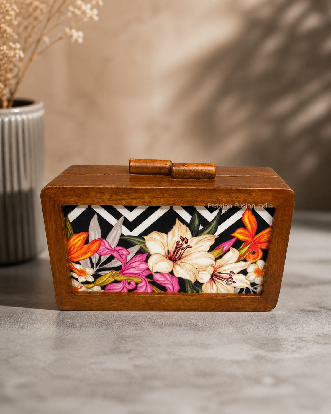 Wooden floral print box with a black zigzag background, displayed against a carved grey backdrop.