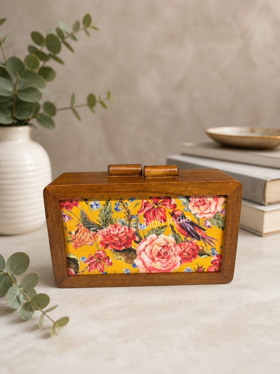 Wooden box clutch with floral and bird print on soft beige décor background.