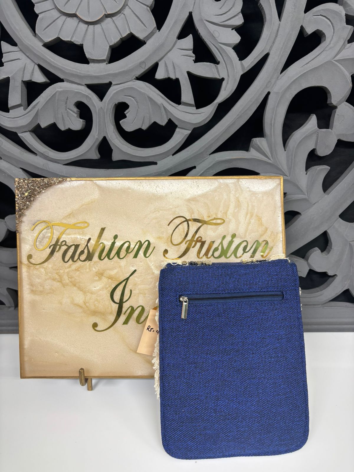 Blue pouch with a gold 'Fashion Fusion' sign in the background