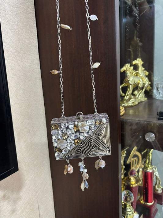 Decorative handbag with embellishments hanging on a wooden surface