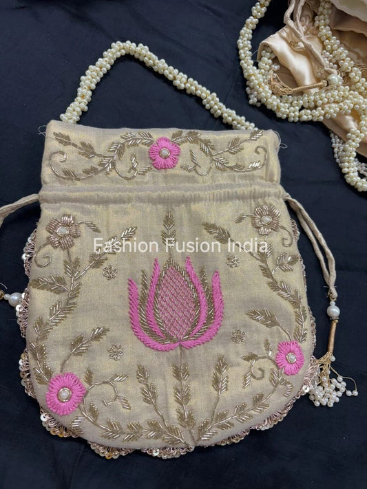 Decorative handbag with floral embroidery and pink flowers on a dark background, branded 'Fashion Fusion India'.