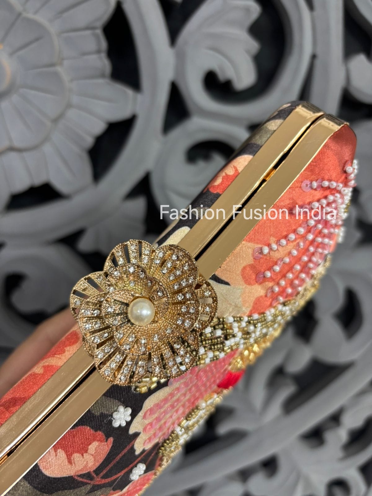 Decorative hair clip with floral design and gold embellishments on a decorative background