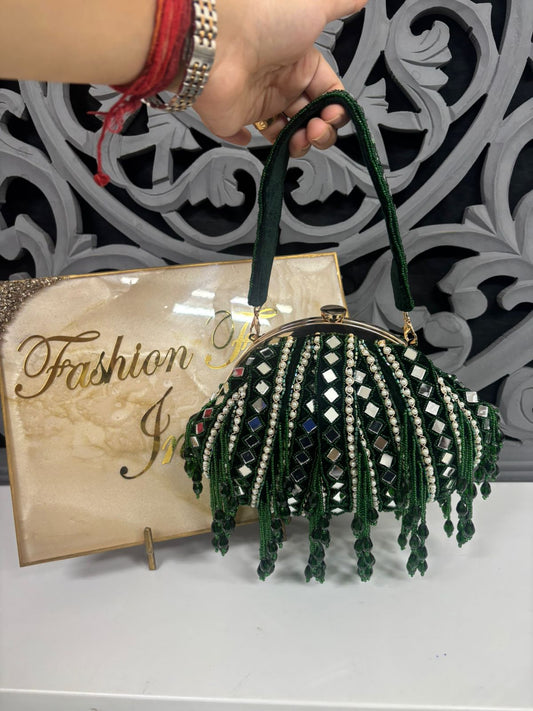 Green beaded handbag held by a hand with a decorative background