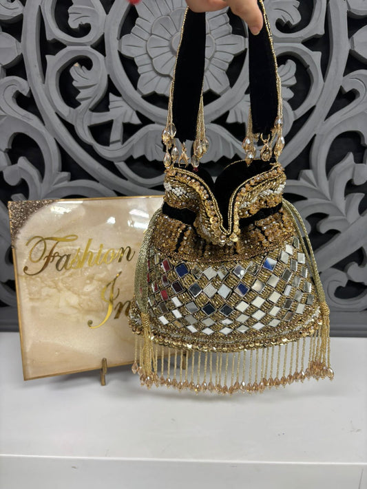Decorative handbag with intricate designs and a 'Fashion' magazine in the background
