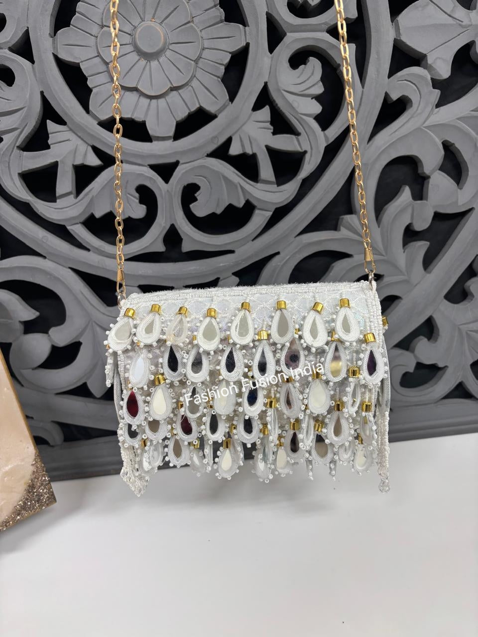 Decorative handbag with beads and chain strap on a decorative wall background